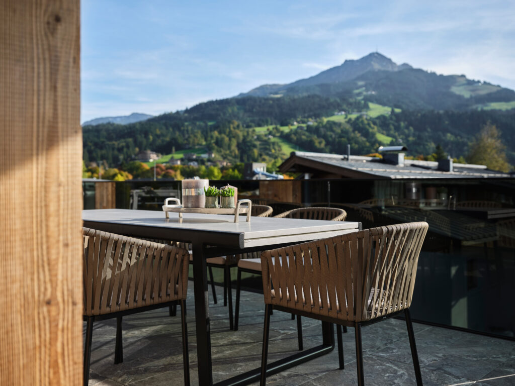 Moderner Esstisch auf Terrasse vor Bergkulisse